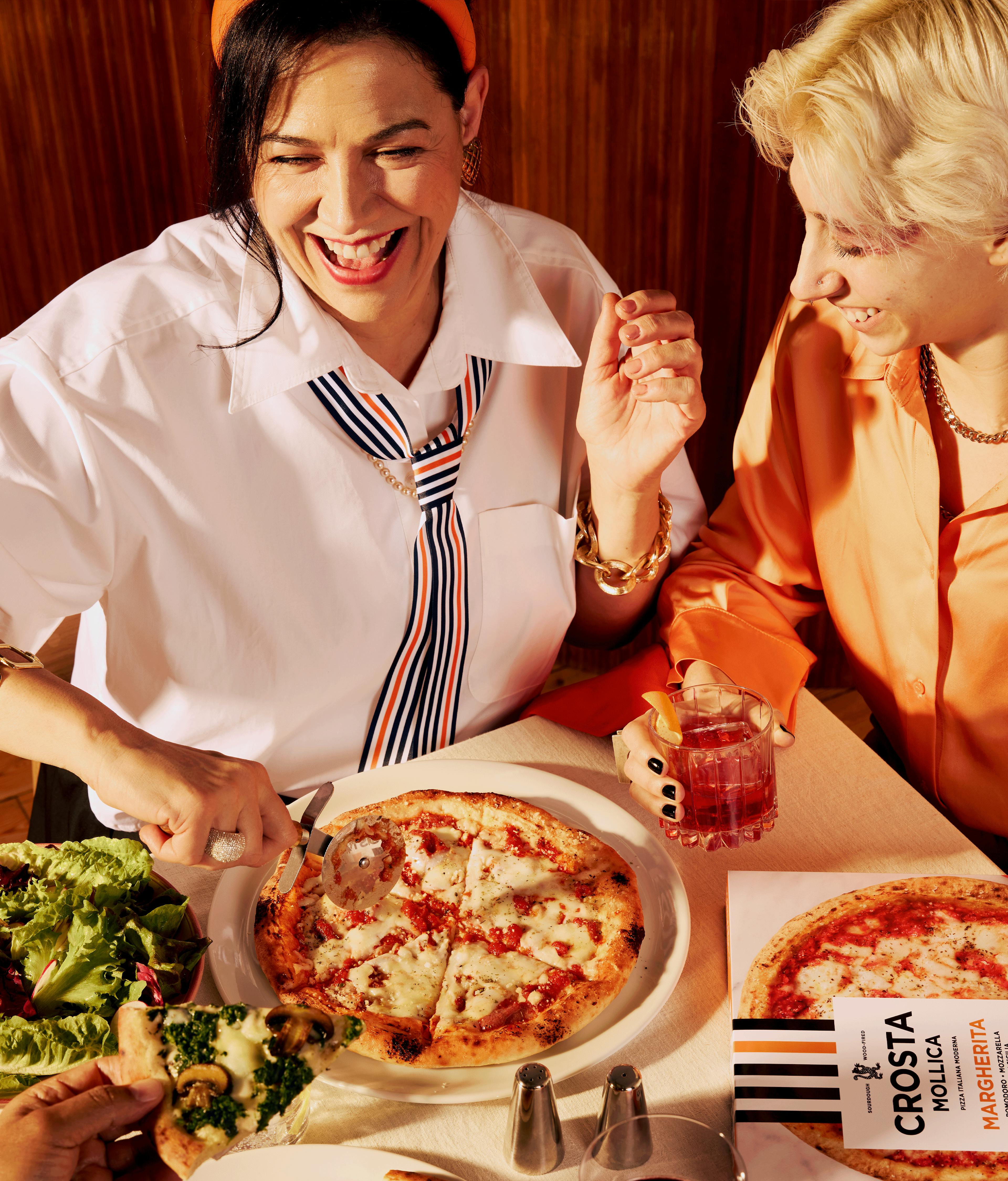 Crosta Mollica's competition: Win a Weekend in Italy for two. Image featuring Margherita Pizza and happy people around the table.