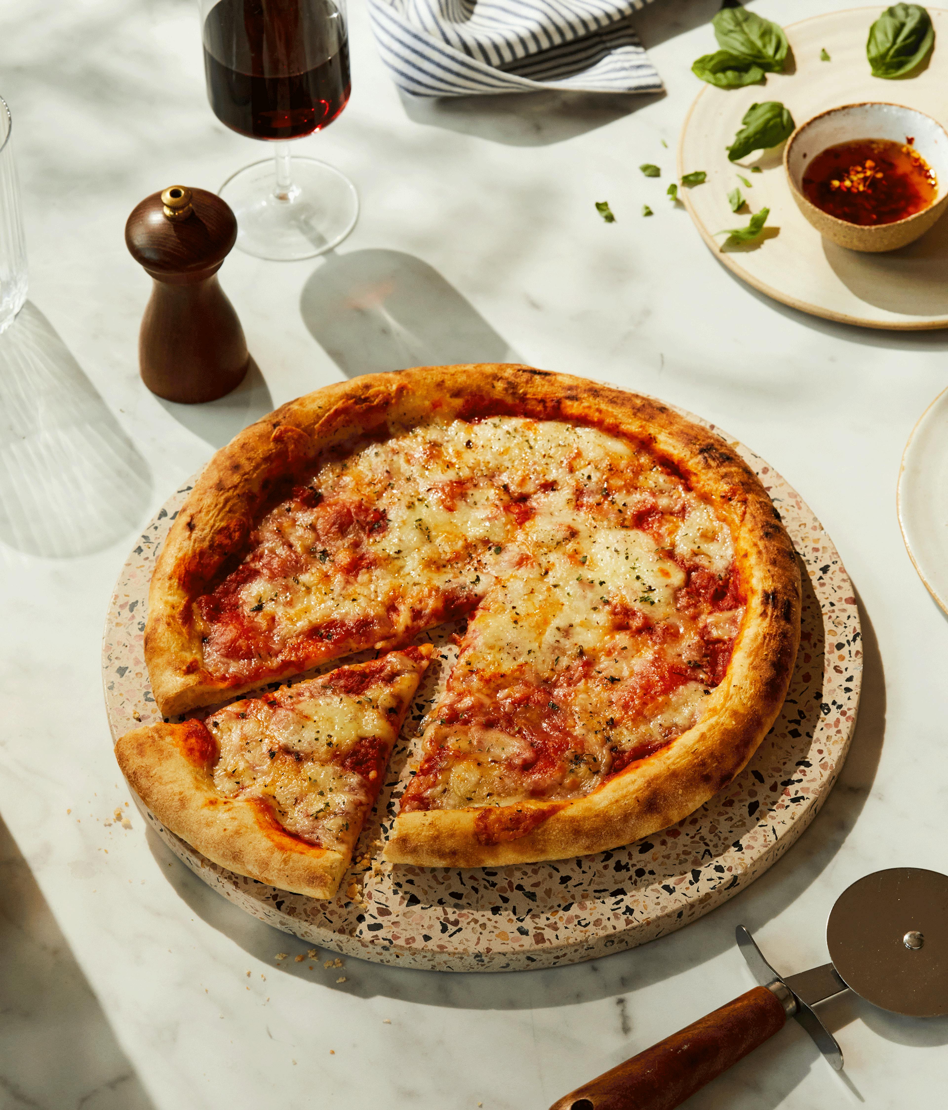 Crosta Mollica’s Margherita Pizza on marble kitchen surface.