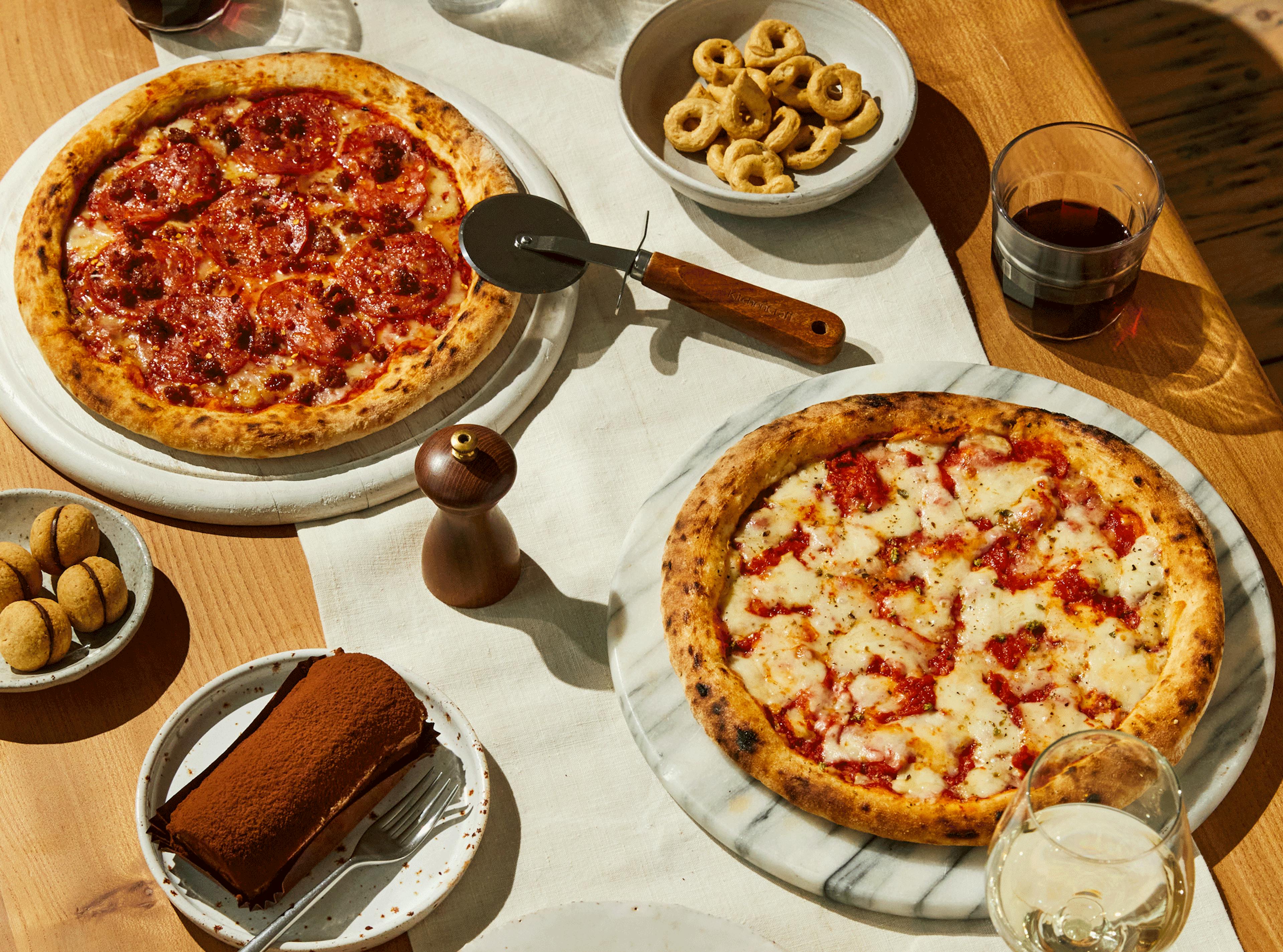 Crosta Mollica Stromboli and Margherita pizzas on a table, ready to eat.