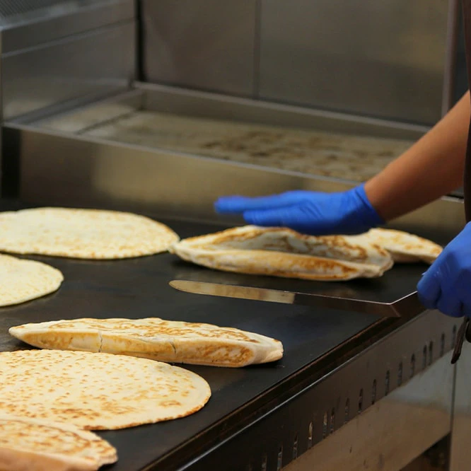 Piadina flatbreads are on a grill.