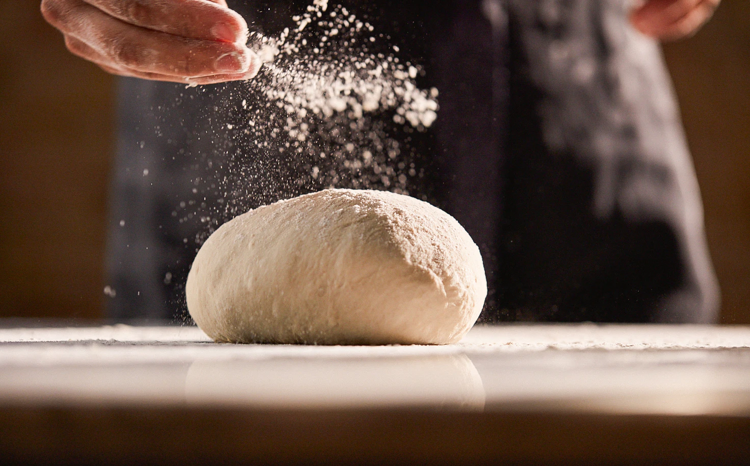 Flour is scattered over a ball of dough.