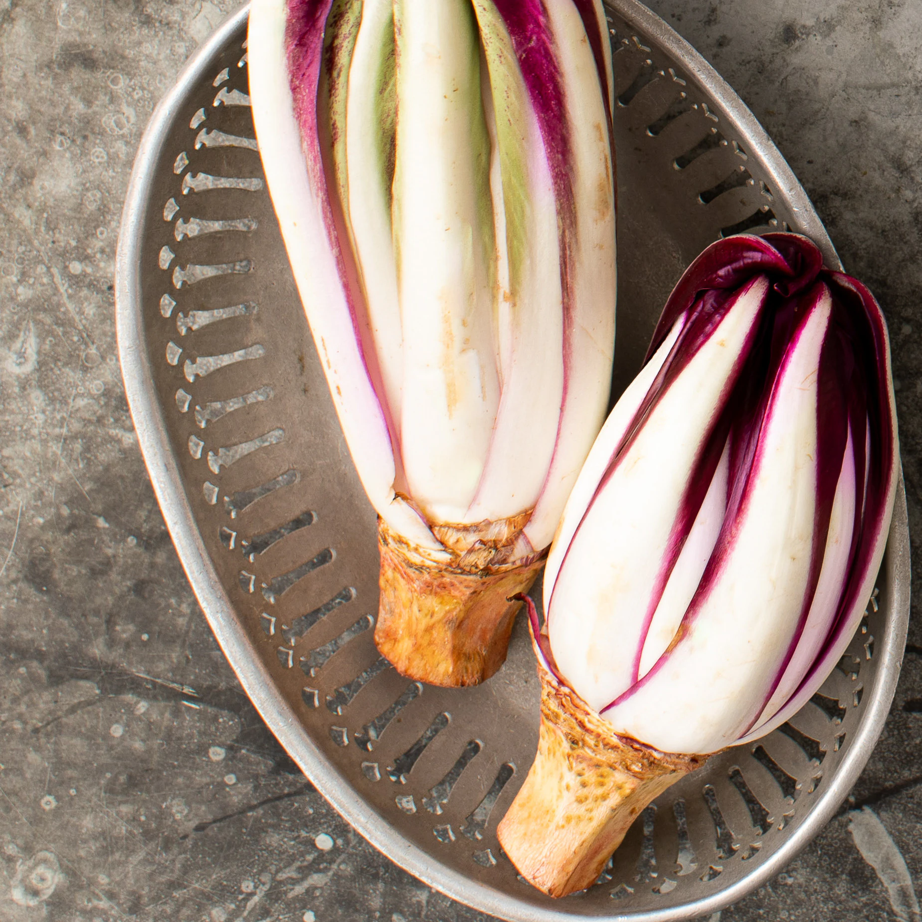 Two heads of radicchio in a metal basket.