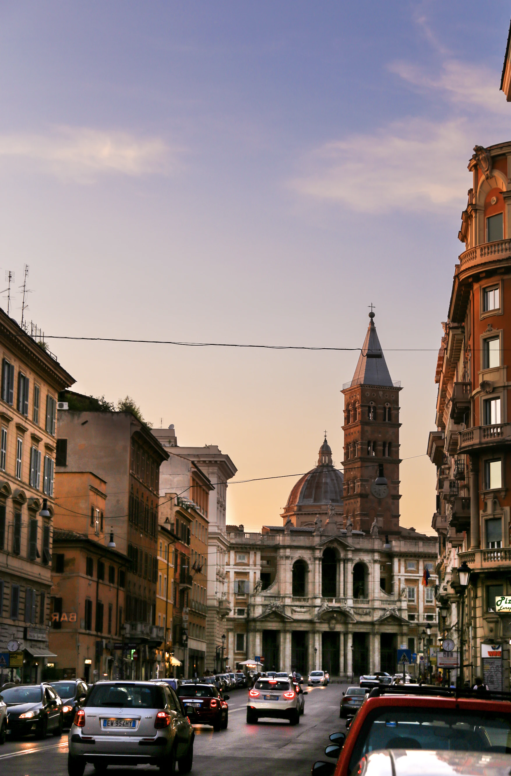 an Italian city street with the sunsetting in the sky.