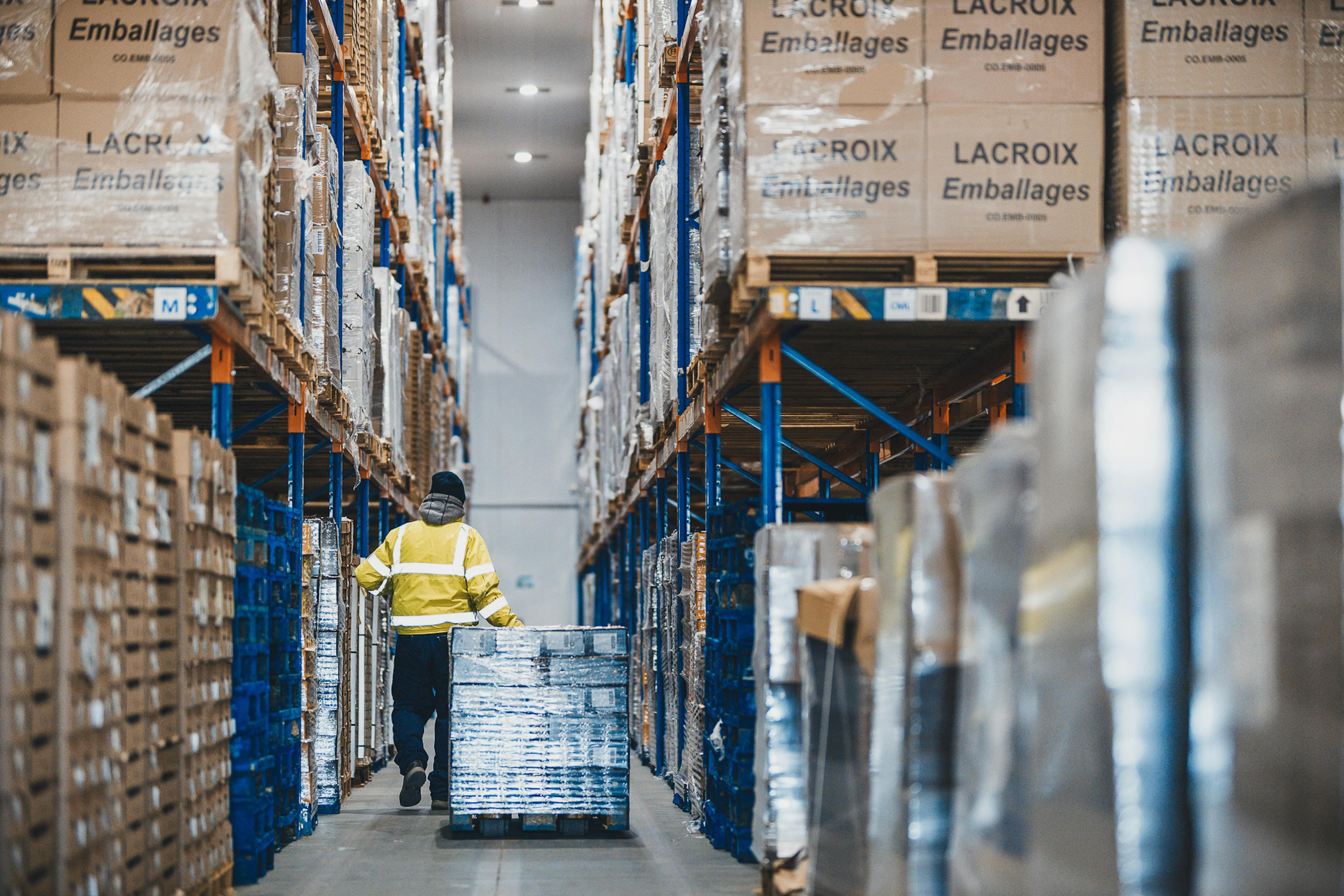 Operational warehouse with worker in PPE