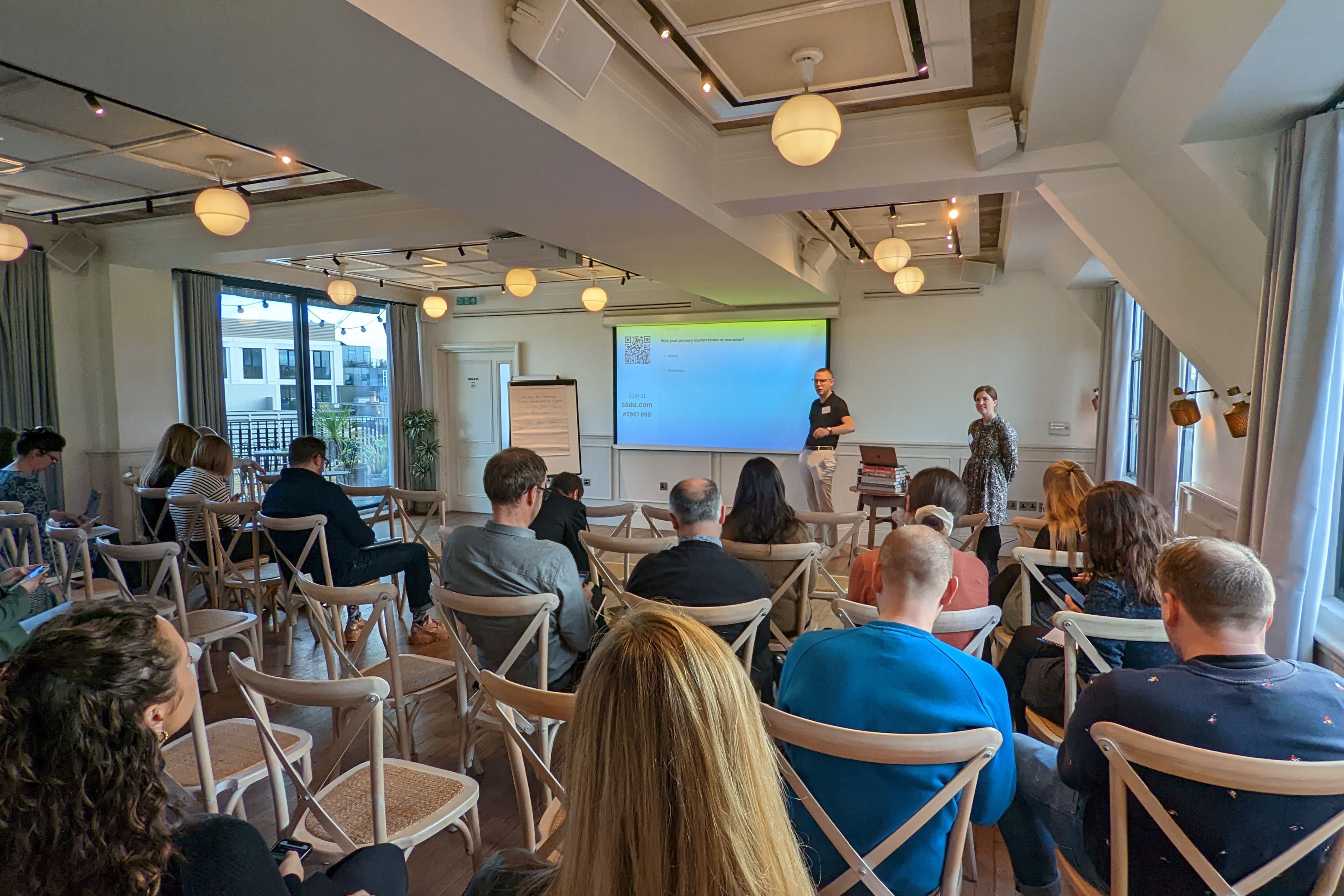 Group of people listening in the conference to two speakers.