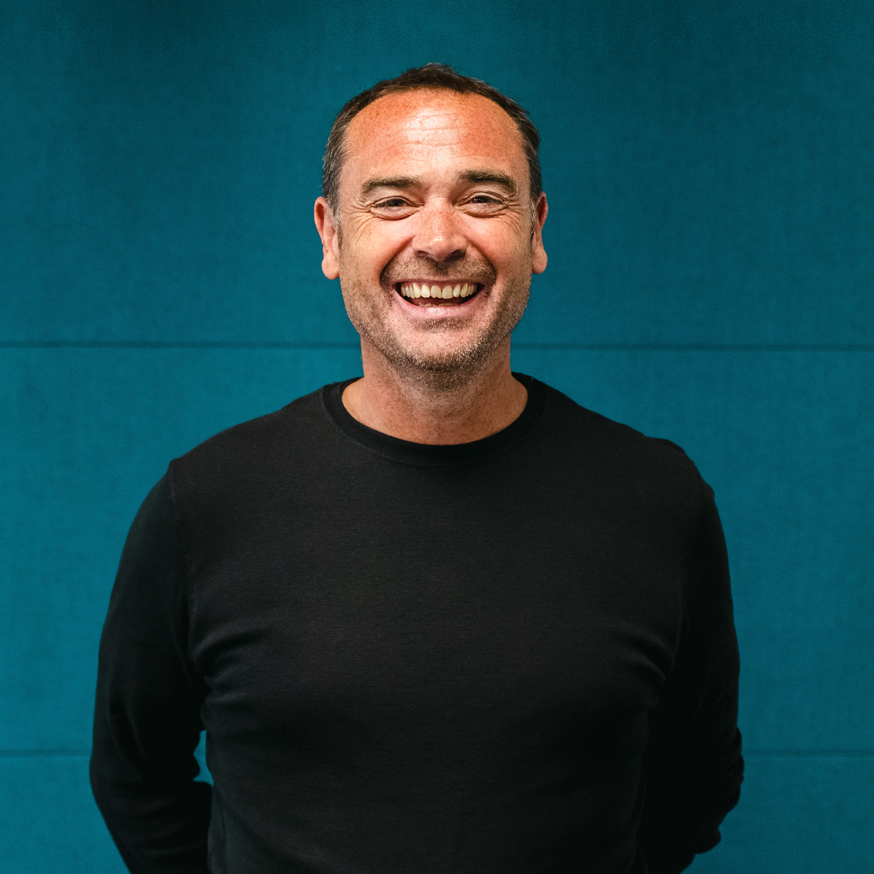 A smiling headshot of Steve Evans on a blue background