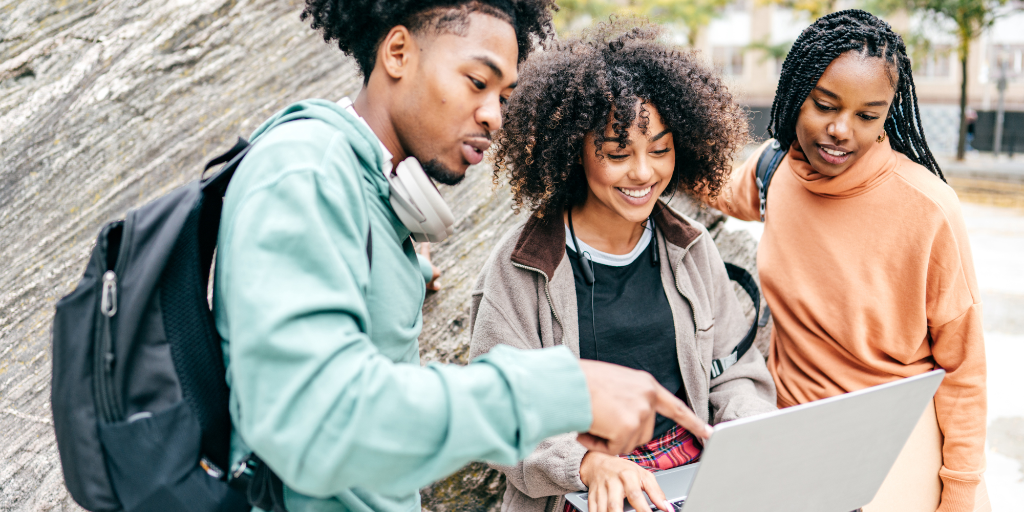 3 students discussing around a laptop - cover image