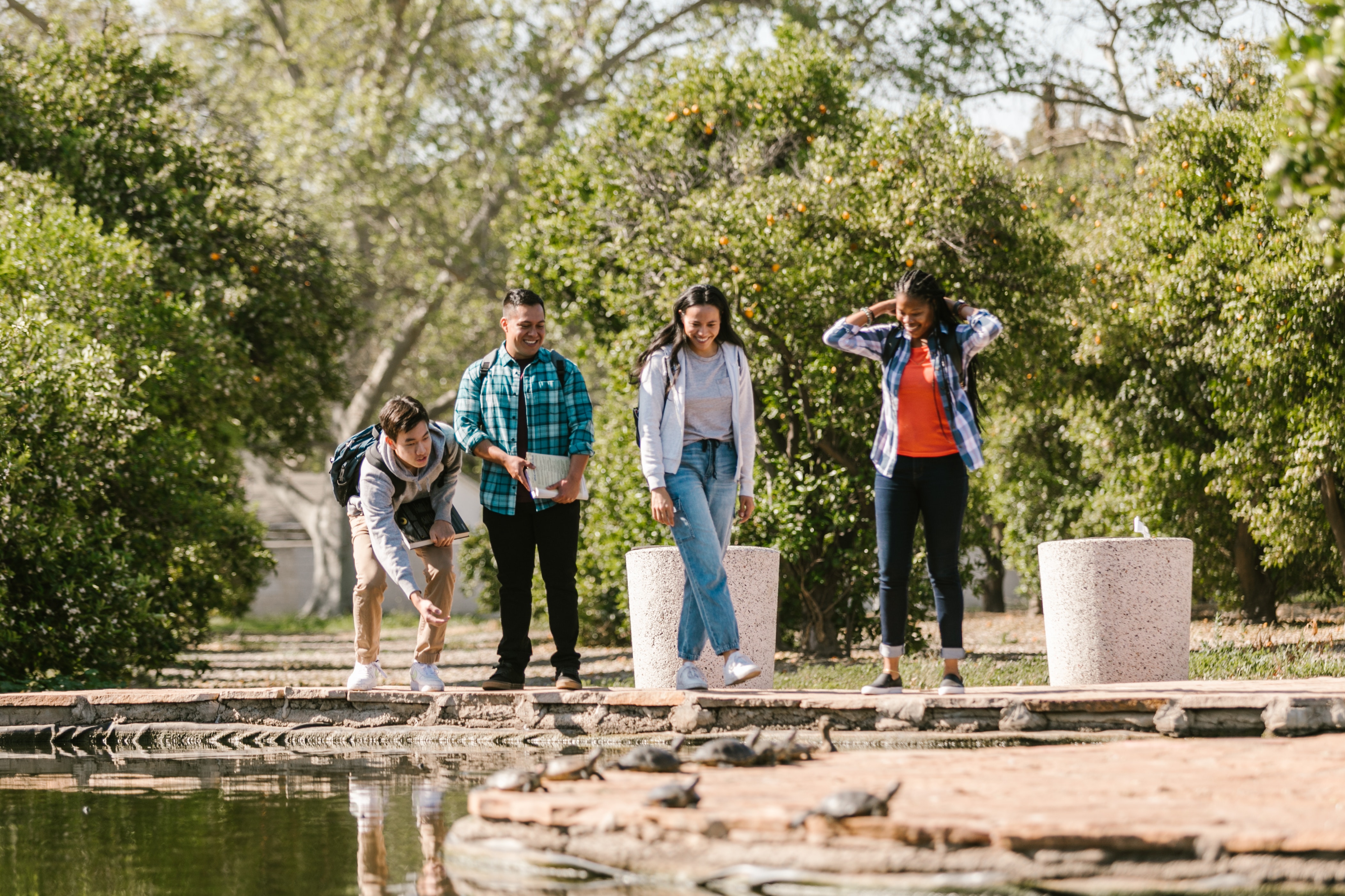 Four students standing by a stream