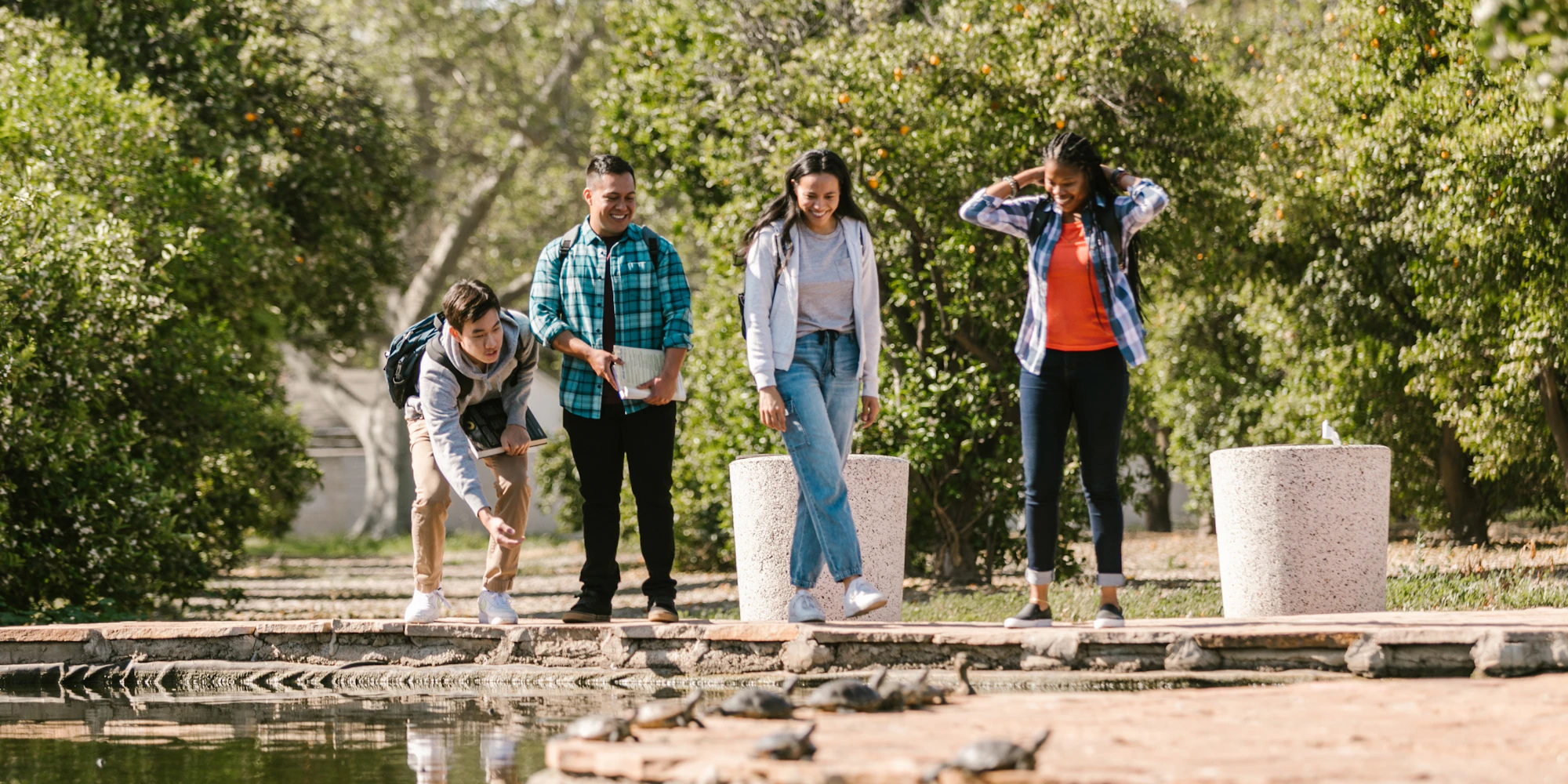 Four students standing by a stream