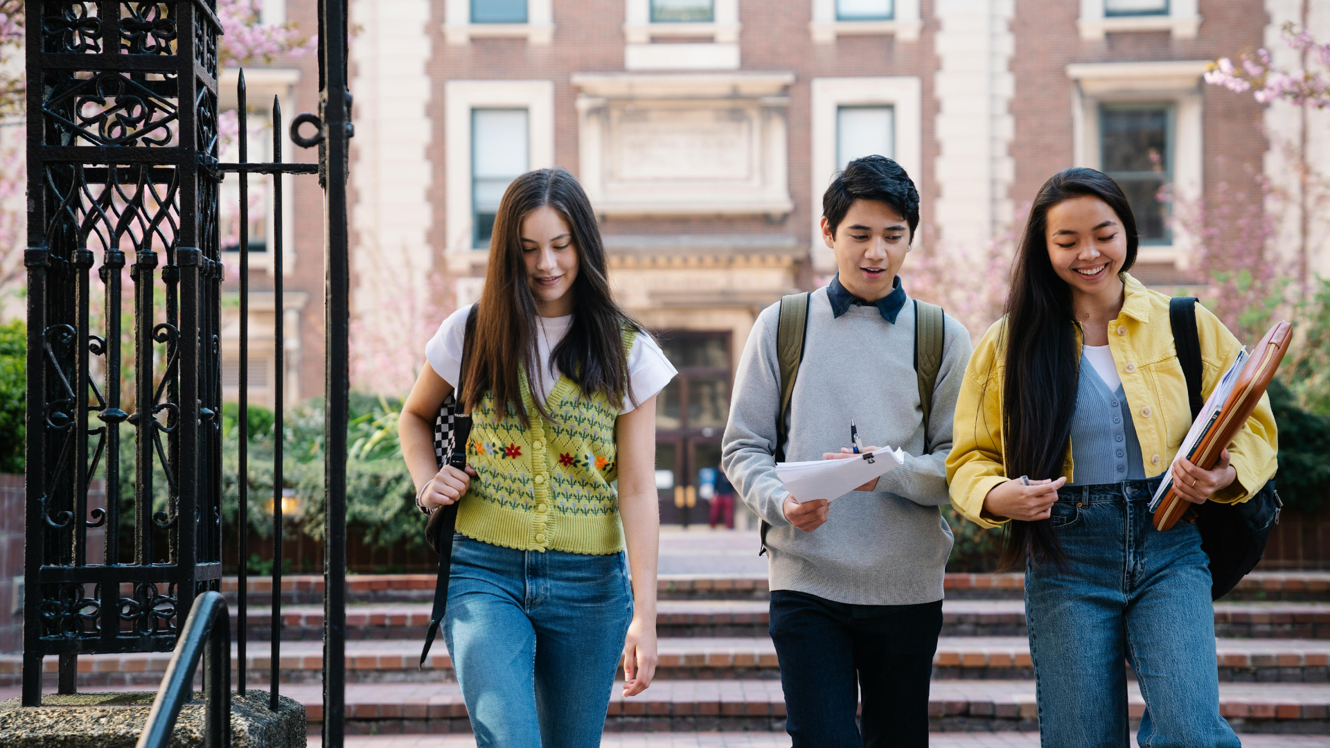 three students walking on a college campus 