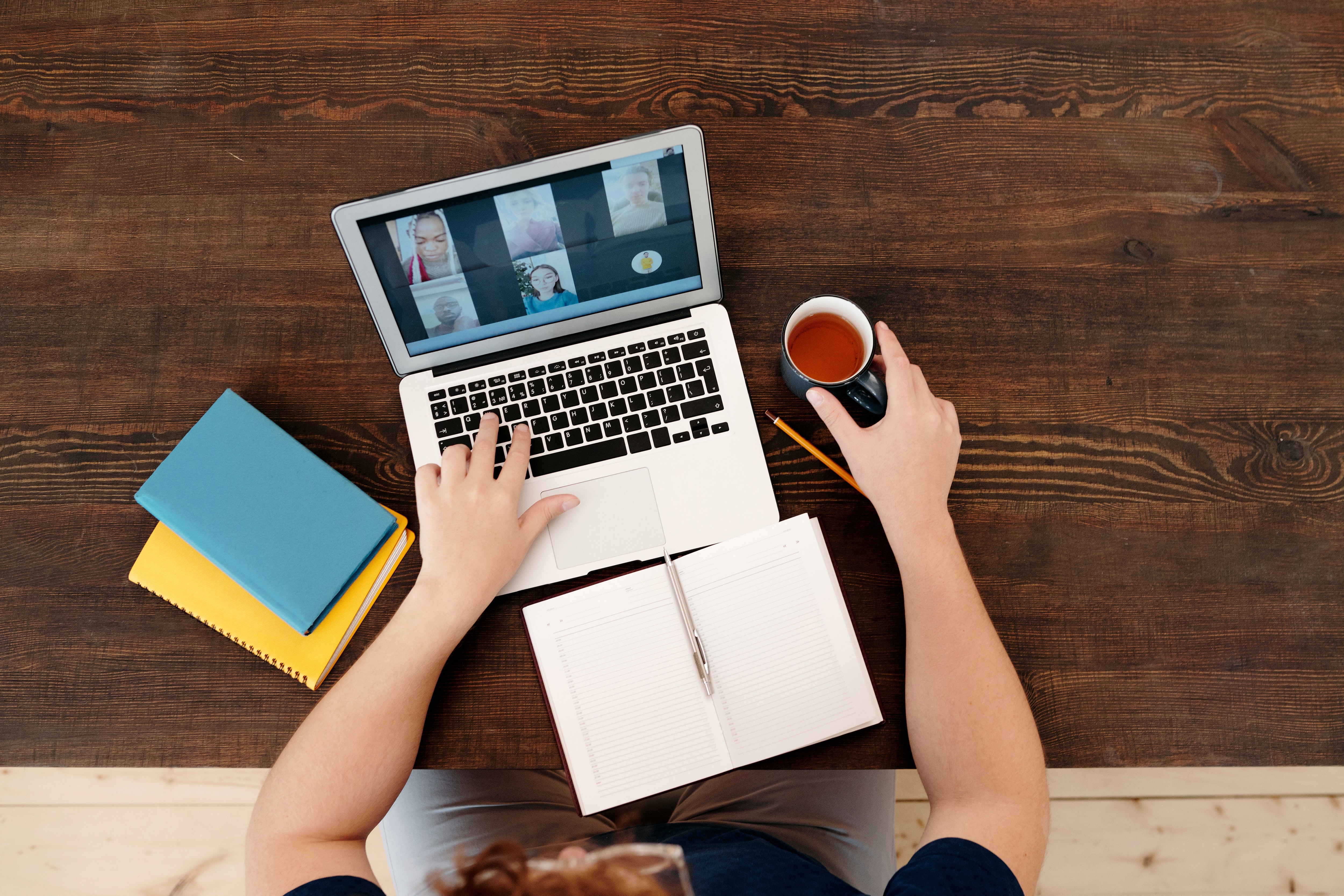 Picture of a table top, with books, a laptop, and a cup of coffee.